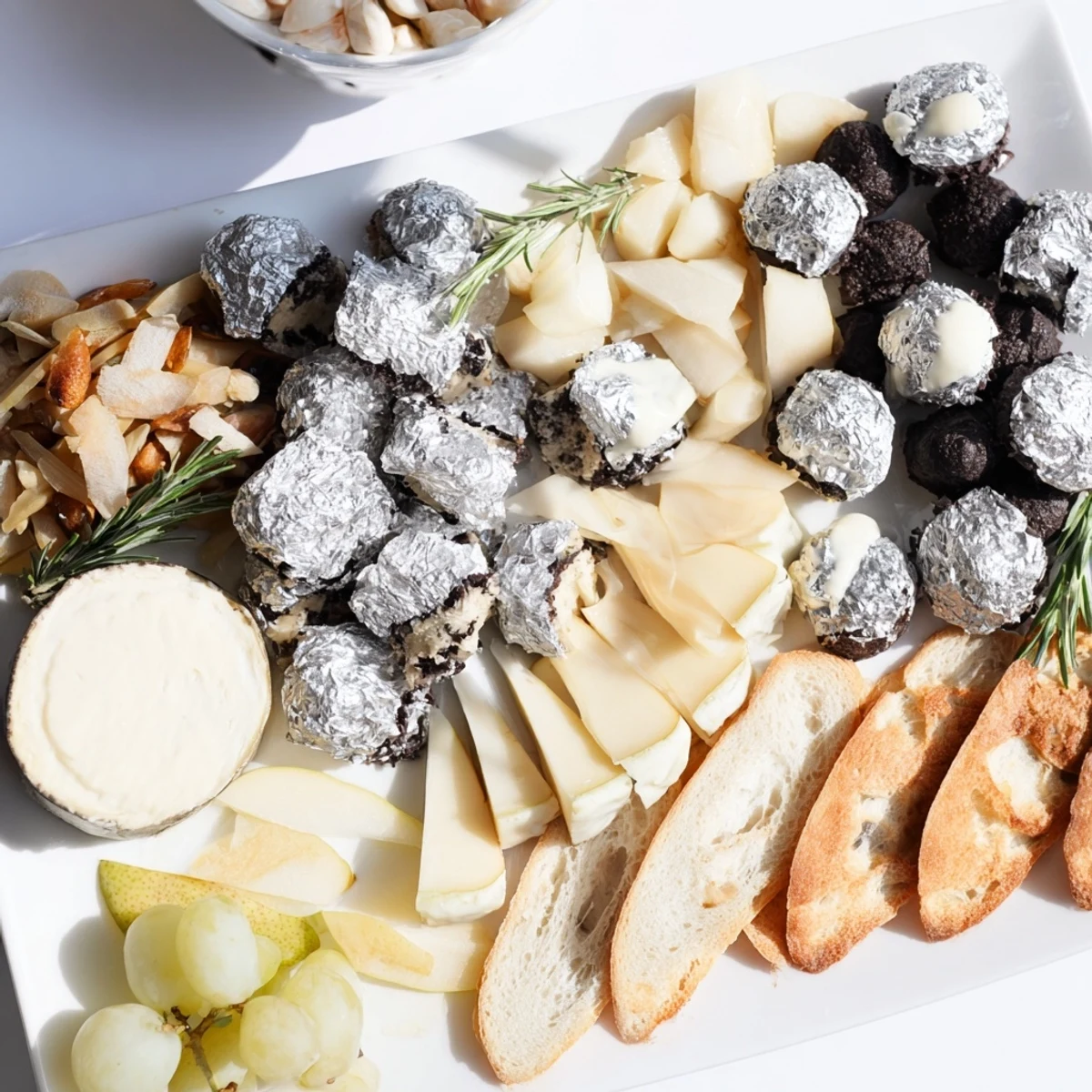 Elegant Silver Screen cheese board featuring creamy truffle brie and silver wrapped chocolates.