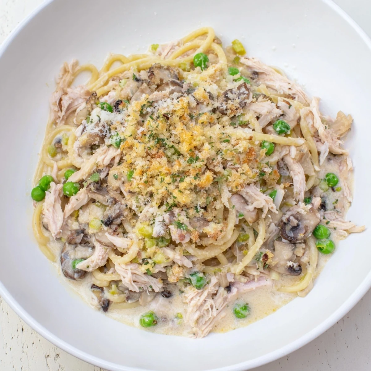 Golden, bubbly Turkey Tetrazzini with a flavorful cheese crust, perfect for a cozy dinner.
