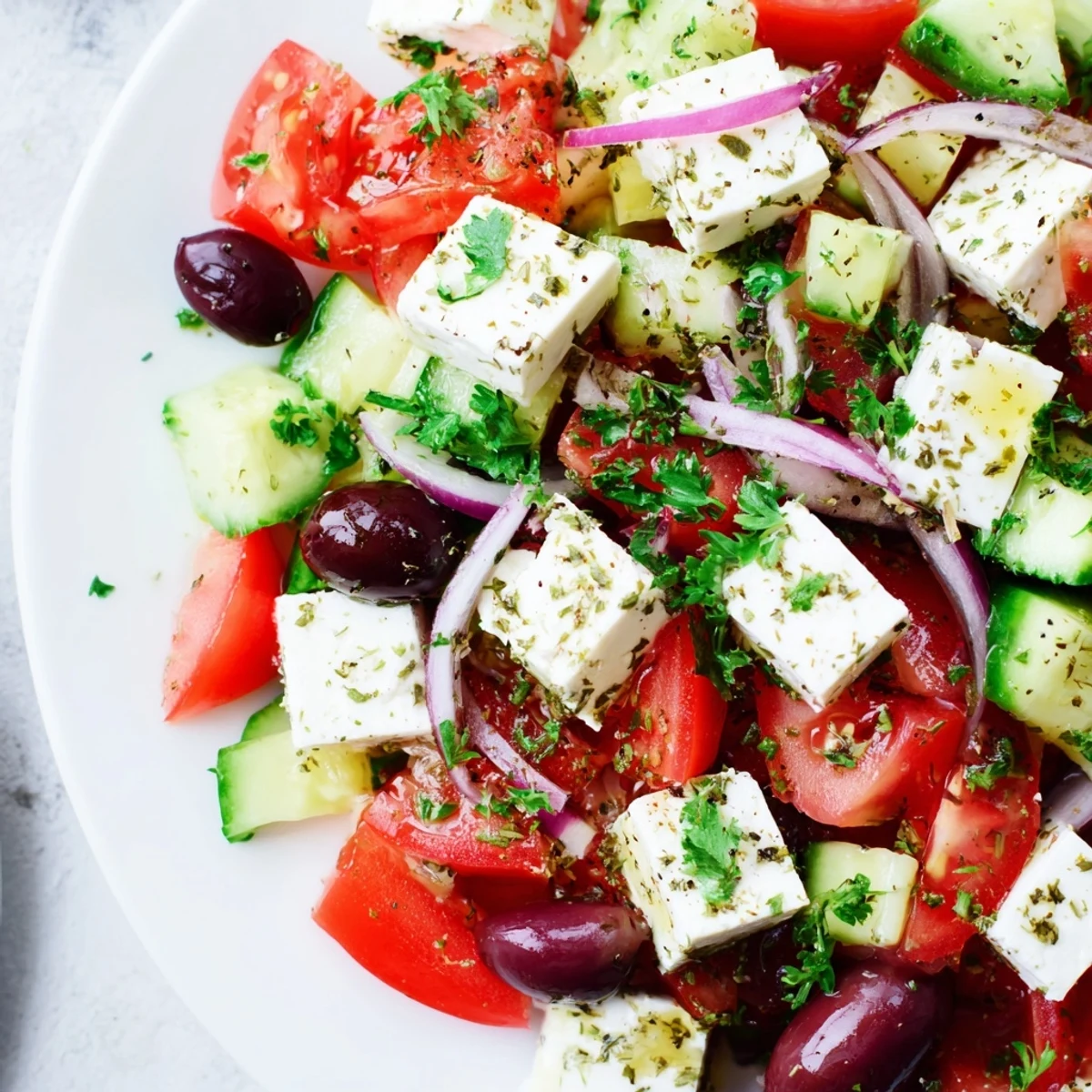 A colorful Mediterranean salad with fresh tomatoes, cucumbers, olives, and feta, ready to enjoy.