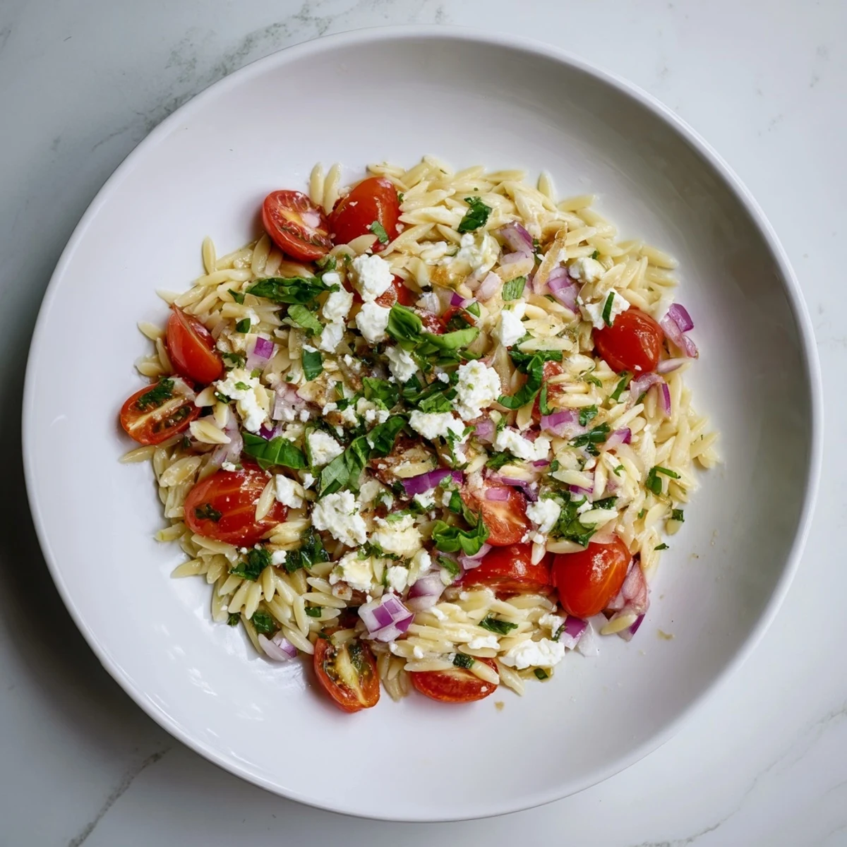 Brightly plated Tomato Feta Orzo, a perfect vegetarian meal with a tangy vinaigrette.