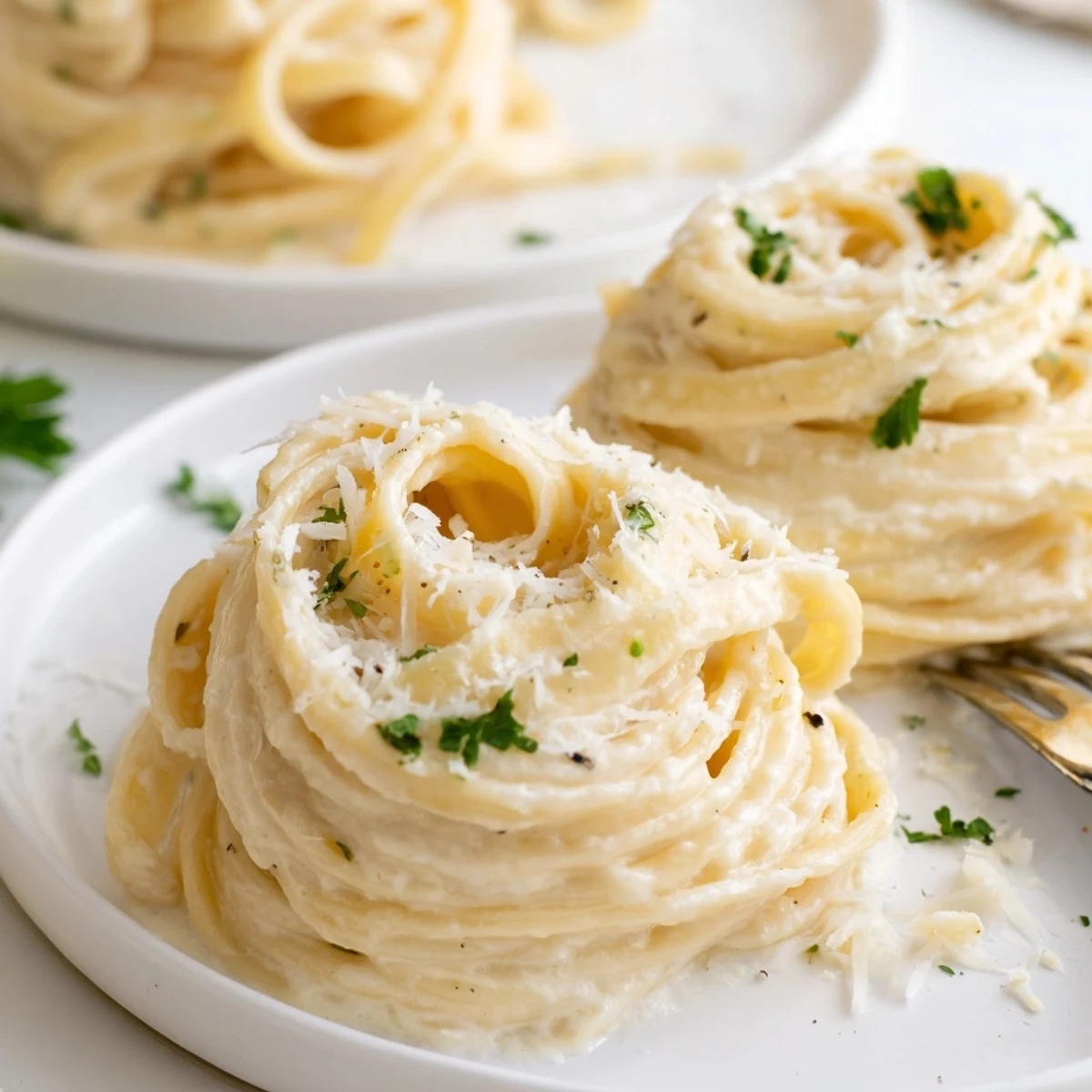 Creamy Easy Creamy Cauliflower Alfredo sauce coats fettuccine, topped with fresh parsley and extra Parmesan cheese.