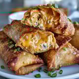 These crispy homemade egg rolls are filled with tangy buffalo chicken dip and green onions, a perfect party appetizer.