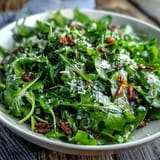 Bright arugula salad with tangy lemon vinaigrette and shaved Parmesan, a refreshing vegetarian side perfect for summer gatherings.