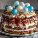 Two-tier vanilla sponge cake with balloon toppers, perfect for graduation celebrations and festive gatherings.