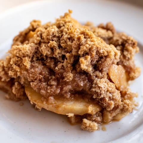A close-up shot of the juicy, bubbly apples beneath the inviting Soft Crumb Apple Crisp topping.