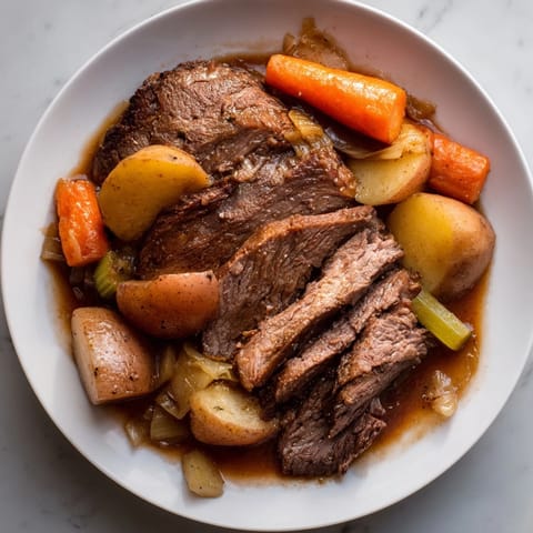 A close-up view of the hearty Everyday Family Favorite Pot Roast, perfectly cooked, with golden vegetables.