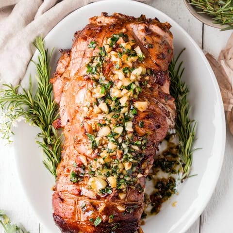 Close-up shot shows beautifully seared Rustic Mint Weeknight Pan-Seared Lamb Chops with fresh mint garnish and sauce.