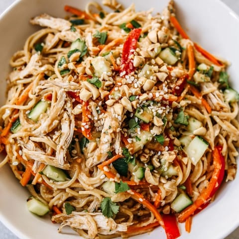 This vibrant Chilled Chicken Noodle Salad shows fresh cilantro and sesame seeds topping a cold dish.