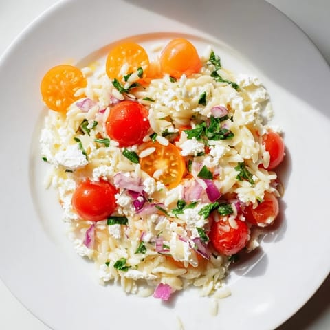 Fresh Tomato Feta Orzo ready to be enjoyed, a Mediterranean dish with herbs and orzo.