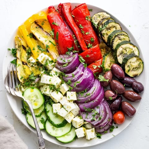 Roasted Greek Salad featuring warm Mediterranean vegetables tossed with zesty lemon-oregano dressing and parsley.