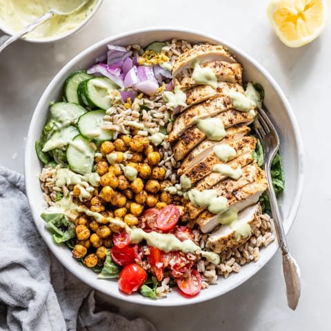 Freshly whisked lemon tahini sauce drizzled over the Mediterranean-inspired power bowl, ready for a healthy, satisfying dinner.