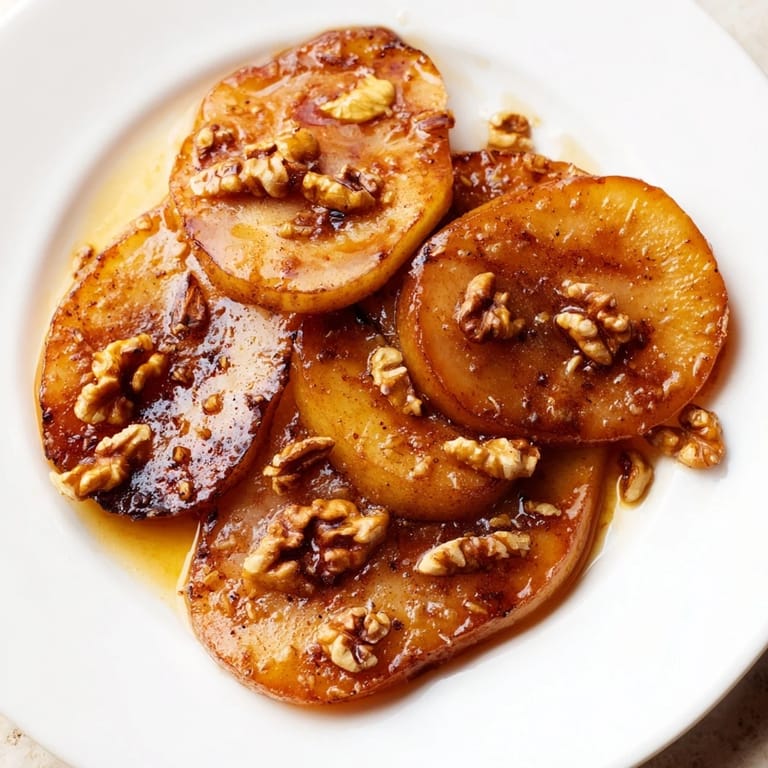 A close-up of Maple-Warm Cozy Plate: Caramelized Pear and Walnut Bake, served warm with creamy vanilla ice cream.