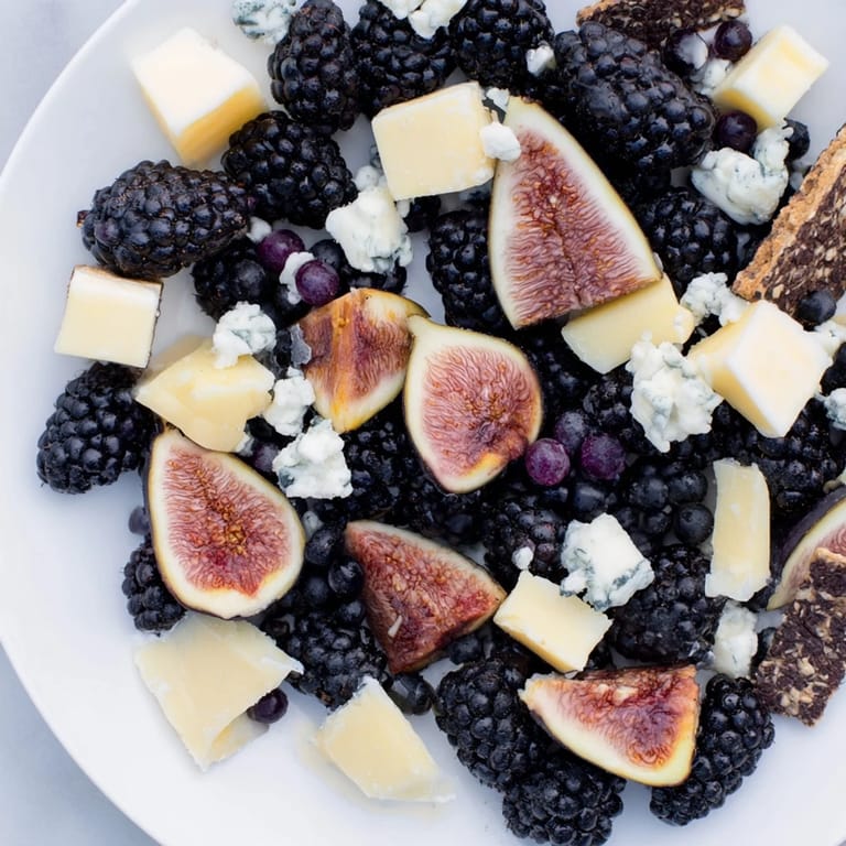 This Deep Indigo Midnight Sky cheese board displays an array of fresh blackberries and figs alongside cheese.