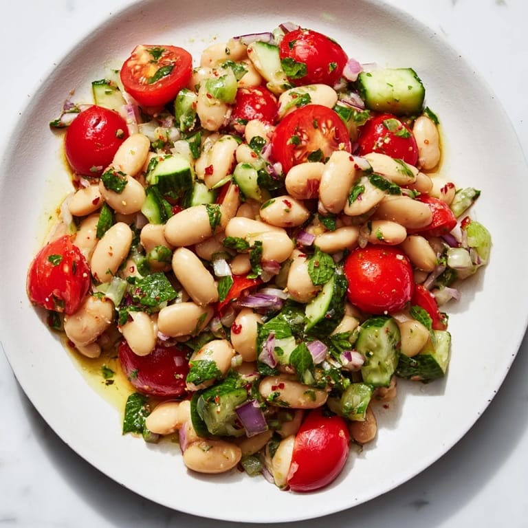 Mediterranean white bean salad drizzled with olive oil, ready for serving alongside grilled dishes.