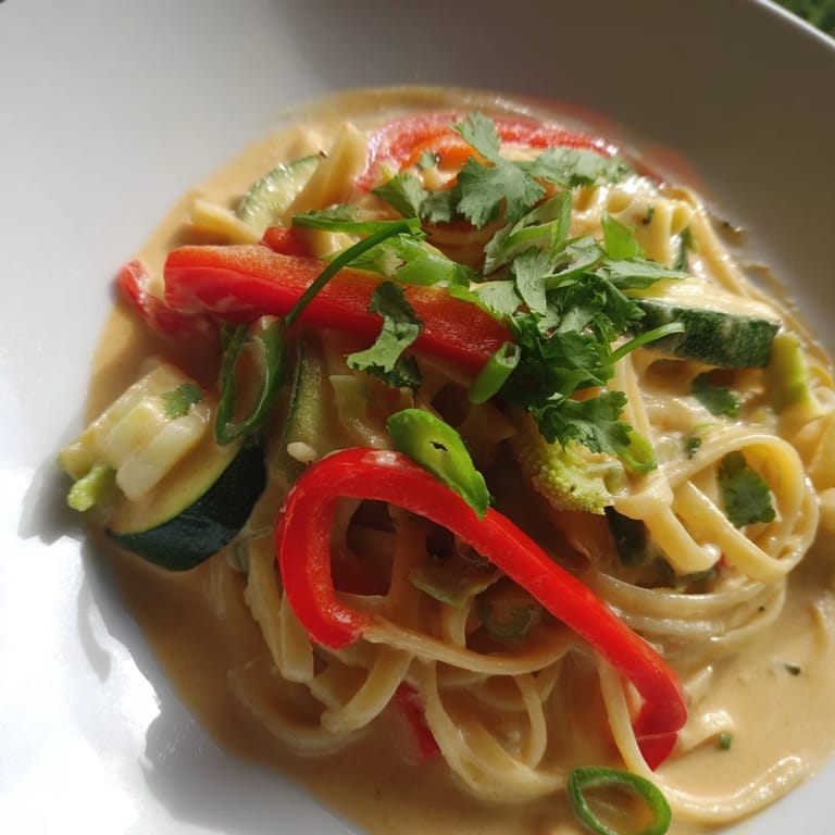 Tender linguine enveloped in creamy, fragrant Thai Curry Pasta, garnished with fresh cilantro.