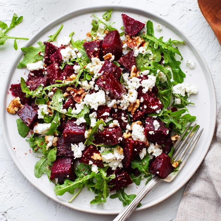 Colorful Roasted Beet Goat Cheese Salad with baby arugula, crumbled goat cheese, chopped walnuts, and a glossy balsamic drizzle.