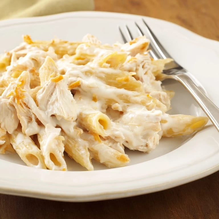 Close-up of Chicken Ranch Pasta Bake with golden edges, garnished with green onions and ready to serve.