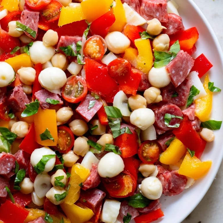 Close-up of a hearty Crunchy Antipasto Chopped Salad with colorful bell peppers, cucumbers, and pepperoncini, ready to serve.