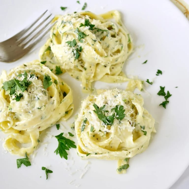 Easy Creamy Cauliflower Alfredo plated with a golden sprinkle of Parmesan and a vibrant parsley garnish.