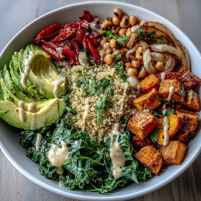 Close-up of a nutritious Black-Eyed Pea Buddha Bowl showing golden roasted vegetables, sliced avocado, and a drizzle of tahini sauce for a vegan meal.