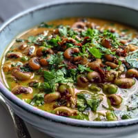 A warm bowl of Black-Eyed Pea Curry with fluffy rice, featuring tender peas in a golden, creamy coconut sauce.